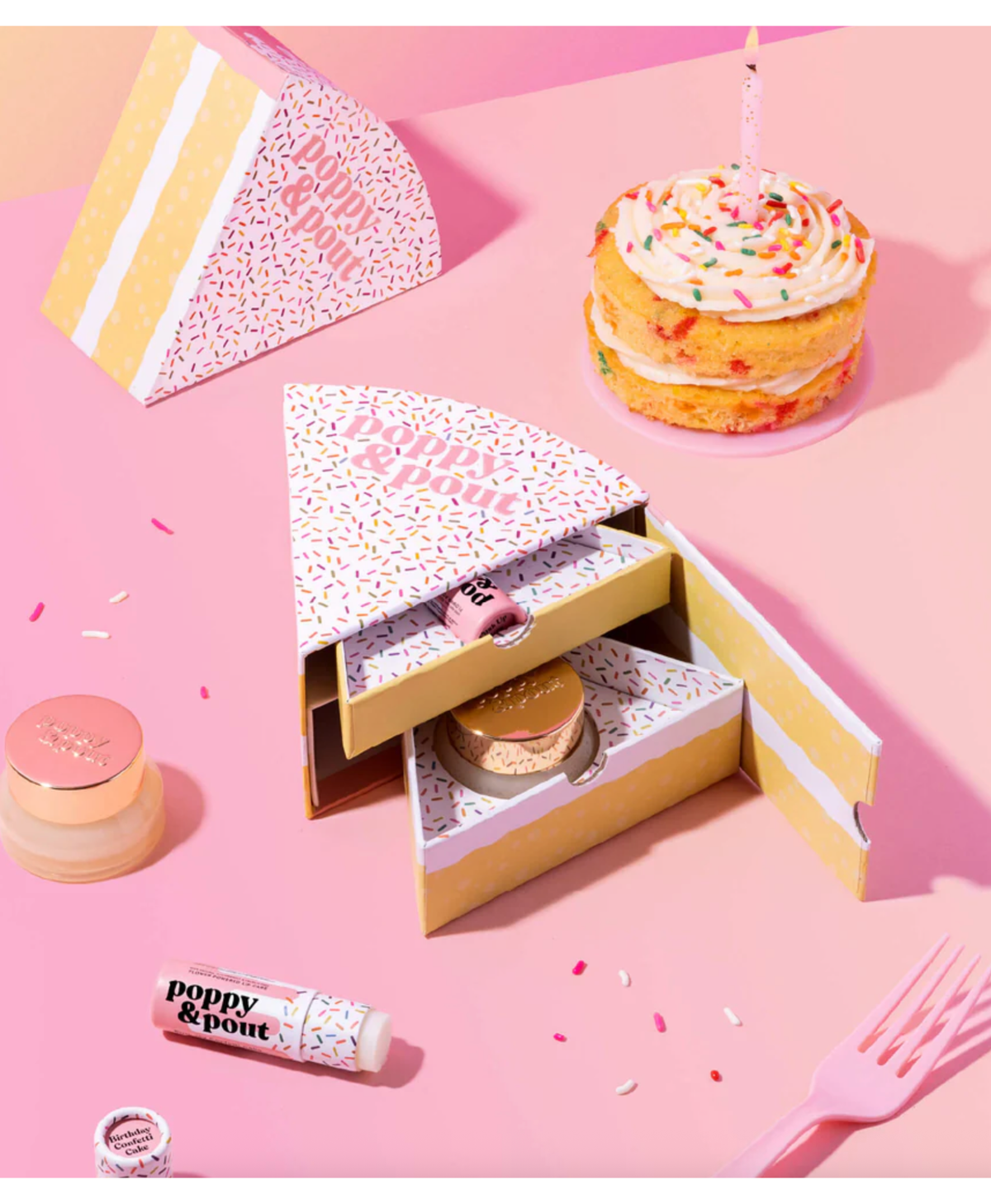 Poppy & Pout lip balm set with on a pink background with a mini cake 
