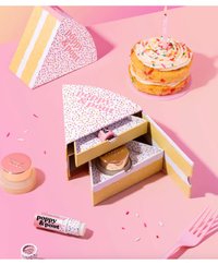 Poppy & Pout lip balm set with on a pink background with a mini cake 