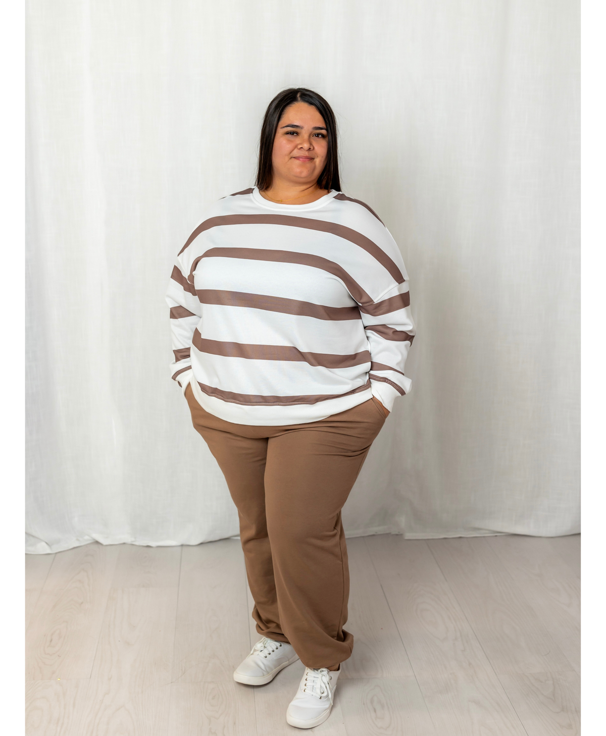 Woman wearing a white and brown top with brown joggers