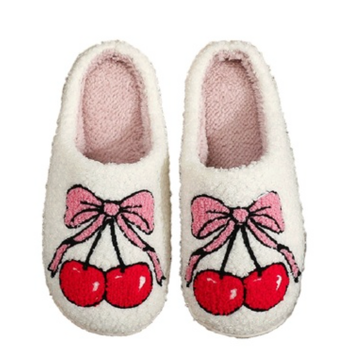 Pair of white slippers with a cherry and bow design on a white background