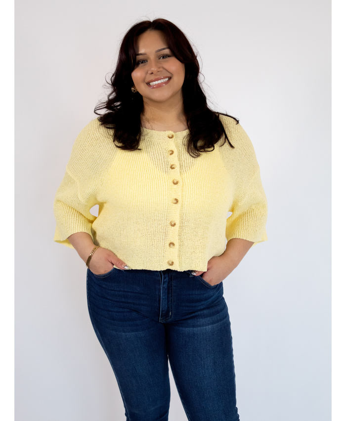 Women wearing a yellow button up top with jeans on a white background