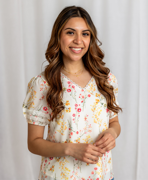 Woman wearing a floral blouse against a plain background