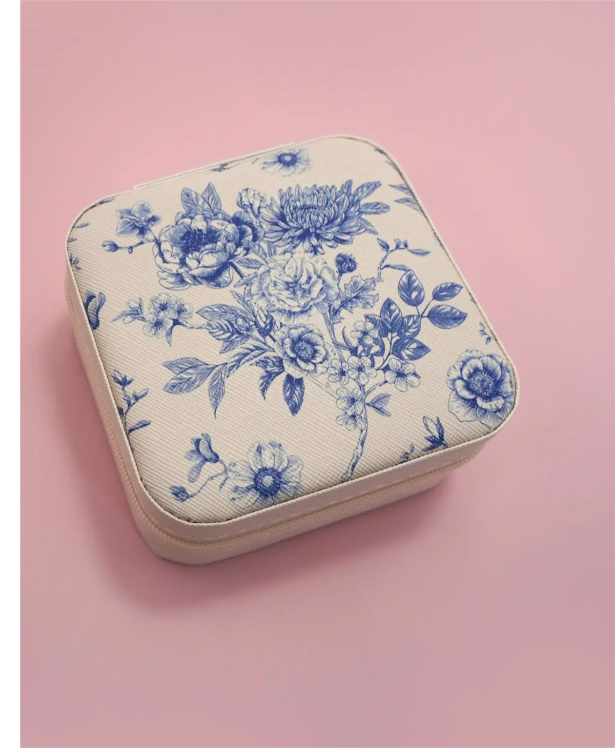 Travel jewelry box with a blue floral print design on a pink background