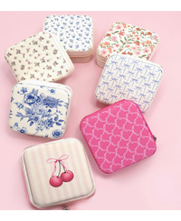 Travel jewelry boxes in a variety of designs on a pink background