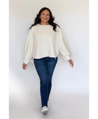 Women wearing a white sweater with jeans on a white background