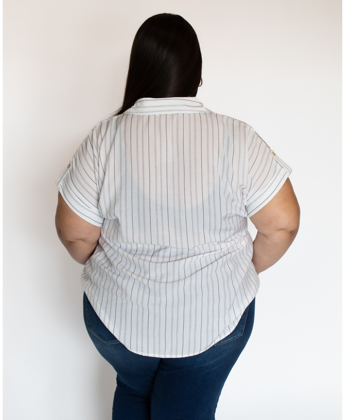 Back of women wearing a striped blouse on a white background